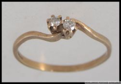 A hallmarked 9ct gold diamond ring with two cathedral set diamonds in a wrap over setting. Size M.