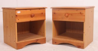 A pair of 20th century antique style pine bedside cabinet tables being raised on bun feet with