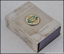 A silver hallmarked machine turned match box holder, having an applied enamel badge to the centre,
