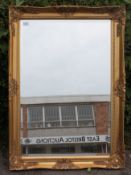 A contemporary antique style gilt framed wall mirror with bevelled edge central mirror.
