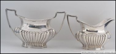 A late Victorian silver hallmarked sugar bowl and creamer by Cooper Brothers & Sons, Sheffield 1900.
