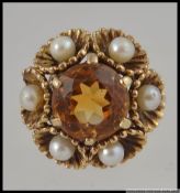 A 9ct gold Art Deco dress ring with central round cut citrine surrounded by scalloped set pearls in