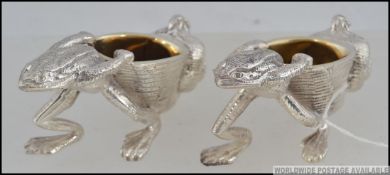 A pair of really heavy novelty silver plated salts in the form of frogs carrying baskets.