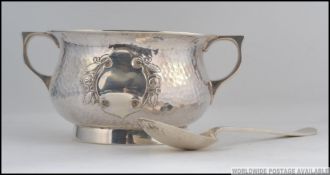 A silver hallmarked hammered Arts & Crafts twin handled sugar bowl ( plain cartouche ) and spoon.