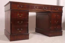 An antique style mahogany and leather twin pedestal writing desk.