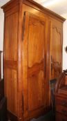 A 19th century French large fruitwood armoire raised on bracket feet with twin full length panel
