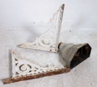 2 Victorian painted cast iron architectural wall brackets together with a salvaged rain hopper.