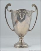 An Edwardian silver hallmarked Art Nouveau trophy being twin handled with acanthus leaf design.
