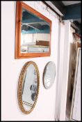 A bevelled edge art deco mirror along with a reproduction oak framed bevel edge mirror and a