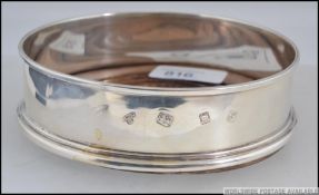 A silver hallmarked wine bottle coaster, having assay marks for London,