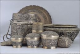 A collection of Indian white metal items to include lidded pots,