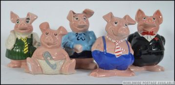 A collection of five retro Natwest pig money banks, from baby to father,