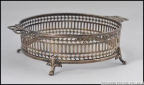 A silver hallmarked wine bottle holder / coaster having lattice worked banded surround raised on