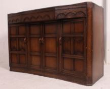 A 20th century Jacobean revival sideboard comprising short drawers over cupboards beneath having