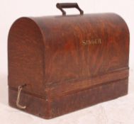 A vintage early 20th century Singer Sewing Machine with oak dome top complete with key.
