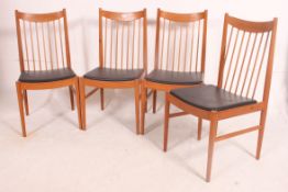 A stunning set of four retro vintage teak wood high spindle backed dining chairs with faux