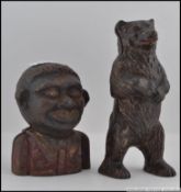 A vintage cast iron negro money bank with penny slot atop of head together with a cast iron money