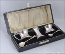 A cased silver hallmarked condiment set comprising lidded pot and open pot,