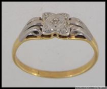 A tested 9ct gold diamond ring with central diamond in a square scrolled setting with scroll triple