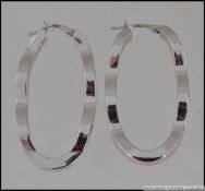 A pair of hallmarked 9ct white gold hoop earrings in a wave form set with CZ. Weight 5.