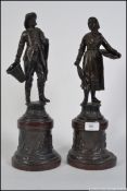 A pair of 19th century spelter figurines raised on plinths of elder gentleman peasant and lady with