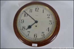 An early 20th century station clock by Enfield set within a circular mahogany case with glass facia