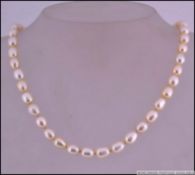 A hallmarked 925 silver and baroque pearl choker necklace with gem set toggle clasp.