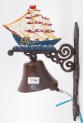 A cast iron 20th century hand painted wall decor exterior bell, with sailboat decoration to top.