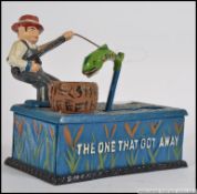 A decorative cast iron money box in the form of a fisherman entitled ' The one that got away '.