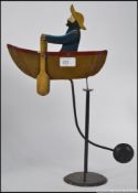 A vintage 20th century wooden hand painted sailor and rowing boat balance figure pendulum.