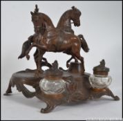 A 19th century continental bronzed desk tidy mounted with cantering horses with a pair of cut glass