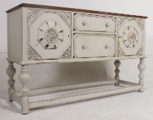 A 1930's shabby chic country painted scrub top sideboard being raised on turned legs with a series