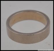 An 18ct / 750 white gold band ring. Size o.5 / Weight 7.