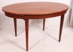 A 1970's Danish style oval teak wood dining table with extending centre being raised on turned and