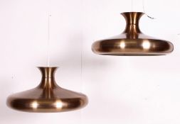 A pair of polished metal retro 20th century conical pendant lamp shades of modernist form.
