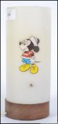 A retro teak based childrens bedside lamp, having a circular full length shade having applied Goofy,