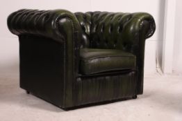 A good quality green leather deep buttoned Chesterfield club armchair having barrel arms with
