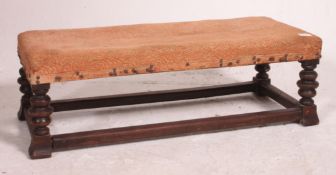 A 19th century long footstool being raised on bobbin cup and cover supports united by lower