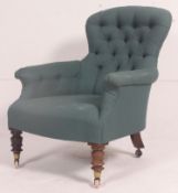 A Victorian mahogany spoon back / button back armchair being raised on turned legs with spoon