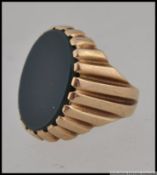 A hallmarked 9ct gold blood stone signet ring with central blood stone in a scalloped setting.