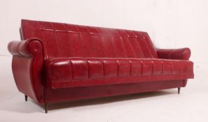 A fabulous retro 1950's red vinyl sofa settee day bed raised on tapering suports.