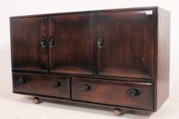 A vintage 1970's beech and elm wood ' Windsor pattern ' low sideboard raised on ball castors having