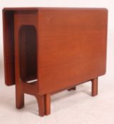 A 1970's retro teak drop leaf dining table raised on pierced end supports,