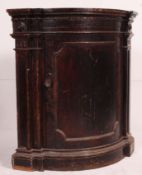 A Victorian oak ebonised corner cabinet raised on plinth with architectural design having flared