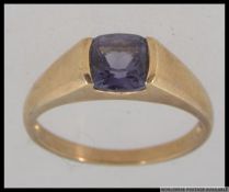 A hallmarked 9ct gold dress ring with large cushion cut amethyst in a rub over setting. Size S.