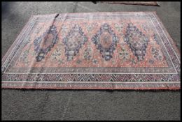 A 20th century Turkish rug being machine woven having central red ground with medallions to centre