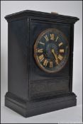 A late 19th/early 20th century black slate eight day mantle clock, enamel dial with Roman numerals.