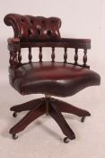 An antique style mahogany and leather captains swivel desk office chair.