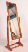 A 20th century pine cheval mirror raised on turned supports with splayed legs united by stretcher.