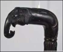 An early 20th century ebonised walking cane of African having an Elephant handle
